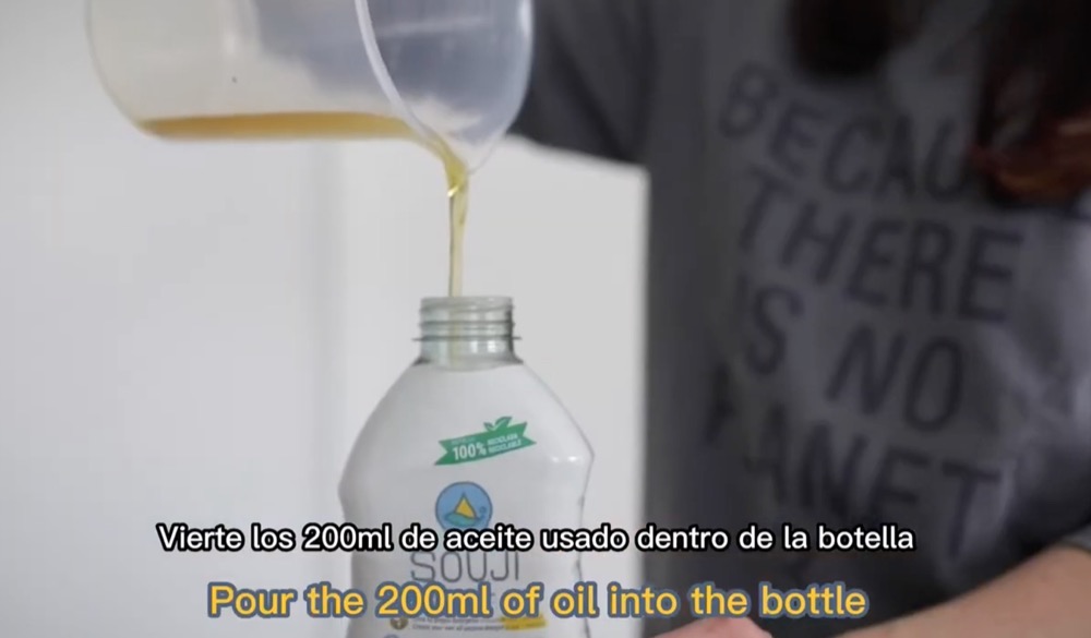 使用済み油をボトルに入れる様子